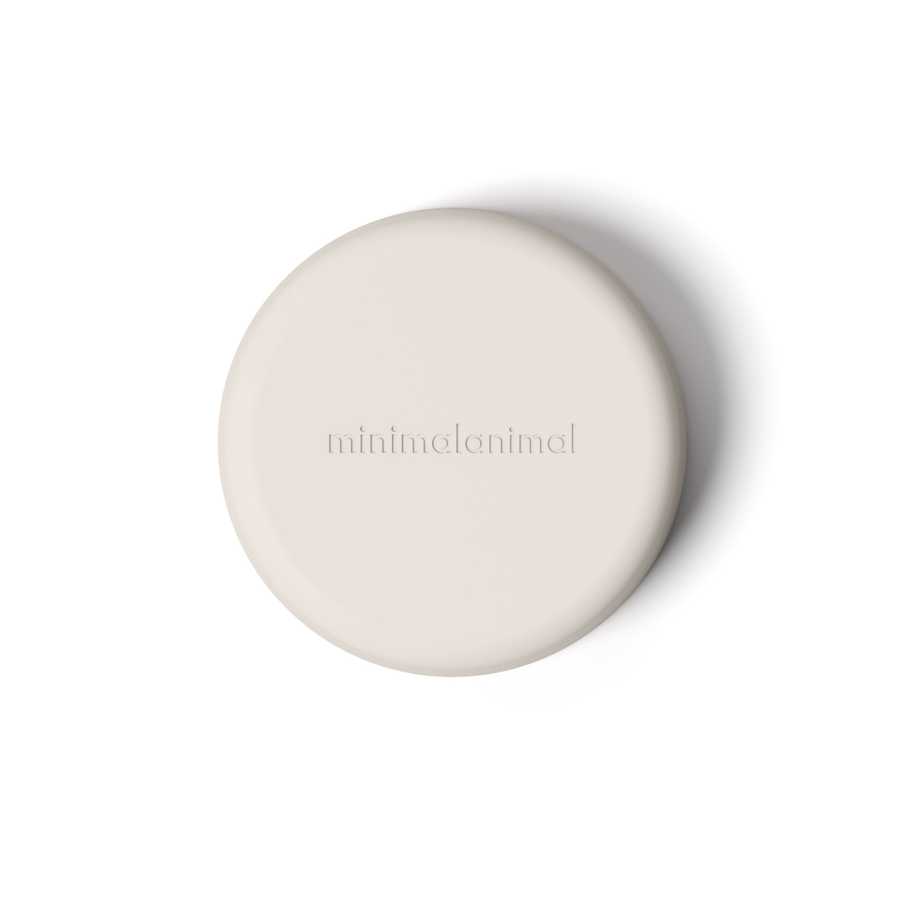 Light tan minimalist circular silicone slow feeder designed to resemble grapefruit for dog use